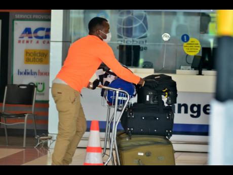 A Jamaican citizen arrives at the Norman Manley International Airport on Saturday, May 30. Effective today, Jamaicans who have been stranded overseas by coronavirus restrictions can return home on regularly scheduled flights.