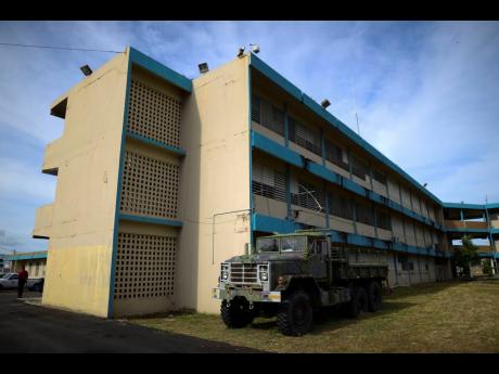 An old military truck used during flooding sits parked at the Carlos Escobar Lopez vocational school, which will be used as a shelter during this year’s hurricane season in Loiza, Puerto Rico.