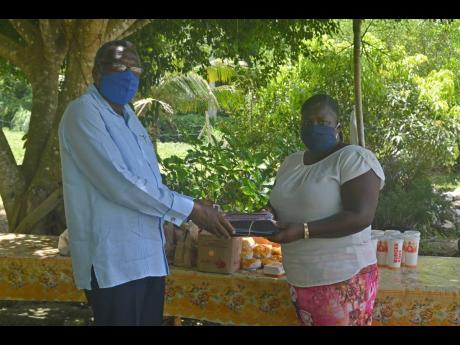 St James Custos Bishop Conrad Pitkin presents a gift of 100 face masks to Cordell Howell-Huie, the administrator of the Mustard Seed Children’s Home in Adelphi, St James. Forty-eight lunches from Burger King were also bought for the home’s children, c