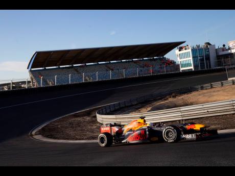 F1 driver Max Verstappen of The Netherlands drives his car through one of the two banked corners during a test and official presentation of the renovated F1 track in the beachside resort of Zandvoort, western Netherlands, on March 4.