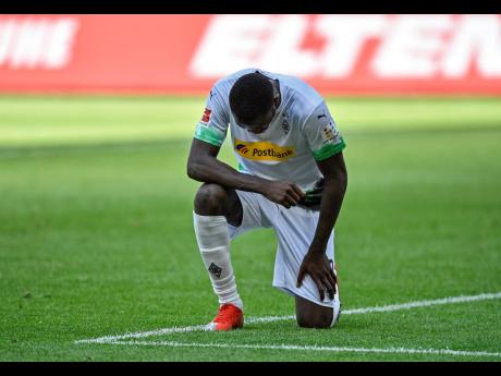 Moenchengladbach’s Marcus Thuram taking the knee after scoring his side’s second goal during the German Bundesliga match between Borussia Moenchengladbach and Union Berlin in Moenchengladbach, Germany, on Sunday, May 31, 2020. 