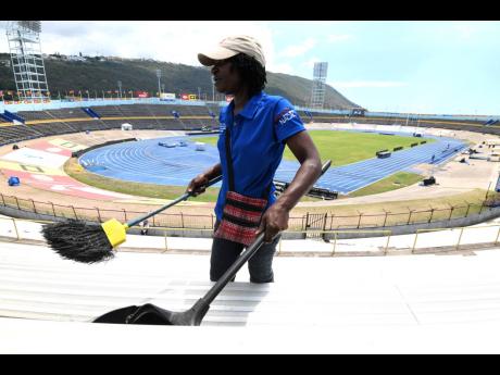 Odette Grant, a resident of the nearby Swallowfield community and temporary employee of Independence Park Limited, conducts a clean-up of the National Stadium ahead of last year’s ISSA/GraceKennedy Boys and Girls’ Athletics Championships.