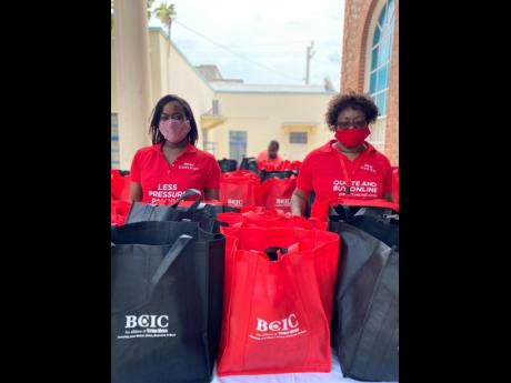 Sponsorship and Public Relations Executive Davee Williamson (left) and Human Resource Manager Doreen Samuels prepare to handover care packages to persons at the Scots Kirk United Church on Duke Street on May 23.