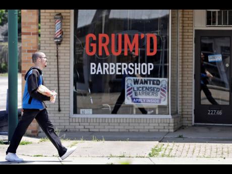 
A man walks past Grum’D Barbershop’s advertising for barbers on Friday, June 5, 2020, in Euclid, Ohio. The markets reacted positively to unexpected job growth on Friday.