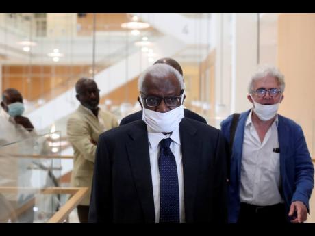 Former president of the IAAF (International Association of Athletics Federations) Lamine Diack (foreground) arrives with his lawyer, William Bourdon (right), at the Paris courthouse, yesterday.  