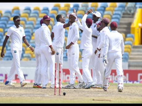 Members of the West Indies team celebrate the dismissal of a wicket during the second Test match against Pakistan at Kensington Oval in Barbados in May 2017.