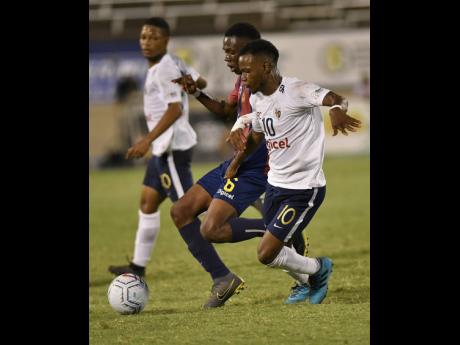 Jamaica College’s Omar Thompson (right) challenges St Andrew Technical High School’s Mikel Riley for ball possession during the ISSA/Digicel Manning Cup final at the National Stadium on Friday, November 29, 2019.