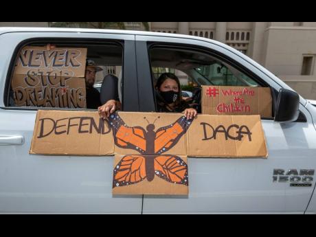 An immigrant family joins members of Coalition for Humane Immigrant Rights of Los Angeles on a vehicle caravan rally to support the Deferred Action for Childhood Arrivals (DACA) Program around MacArthur Park in Los Angeles on Thursday. DACA recipients reac