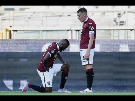 Torino’s Nicolas Nkoulou (left) kneels as he celebrates with his teammate, Andrea Belotti, after scoring his side’s opening goal during their Serie A match against Parma at the Olympic Stadium in Turin, Italy, on Saturday.