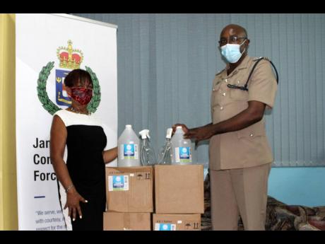 Vana Taylor (left), St Ann Chamber of Commerce president and Jamaica Hotel and Tourist Association area chairperson, making a donation to Superintendent Calvin Small at the St Ann police divisional headquarters. 