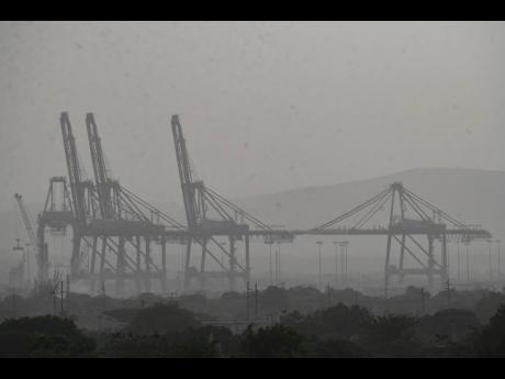 Cranes at the Kingston Freeport Terminal Limited are shrouded by plumes of dust from the Sahara Desert, affects the visibility in the Jamaican capital on Monday. This year’s phenomenon is the thickest in decades to reach the Caribbean Sea and some of the