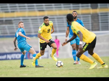 Jamaica’s Adrian Mariappa (second left) dribbles away from Aruba’s midfielder Erik Santos (left) and Terence Groothusen (obscured) during a Concacaf Nations League game at the National Stadium on Saturday, October 12, 2019.