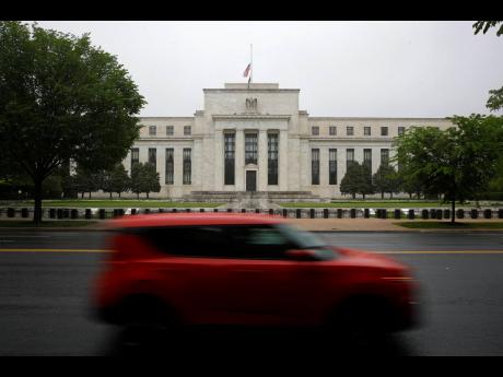 In this May 22, 2020 photo, a car drives past the Federal Reserve building in Washington.