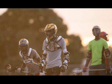 Nathanel Moulton (centre) and other members of Jamaica College’s lacrosse team go through a training session at the Jamaica College Ashenheim Stadium on January 16, 2020.