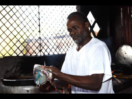 Chef Selvyn Willims, seen here preparing fish, said that the two-month shuttering of Hellshire Beach cost him dearly. 