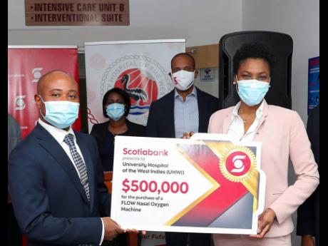 Audrey Tugwell Henry (right), executive vice-president of Retail Banking, presents an additional donation of $500,000 to fund the purchase of a Flow Nasal Oxygen Machine which can help to improve the outcome of persons requiring respiratory treatment and p