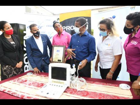 Chief medical officer at the Sir John Golding Rehabilitation Centre, Dr Rory Dixon (third right), explains the use of the portable ultrasound machine to  (from left) Latoya Aquart-Foster, CHASE project manager; Johann Heaven, CEO, Proven Wealth; Kecia Tayl