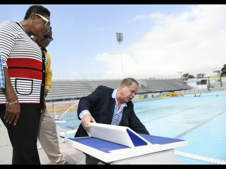 Martin Lyn (right), president, Aquatic Sports Association of Jamaica, explains the technologies involved in the starting blocks to Minister of Sport Olivia Grange (left) and Major Desmon Brown, general manager, Independence Park Limited, during the present