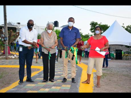 Dr Nigel Clarke (third left) is joined by (from left) Julian Patrick, director of product development and community tourism at the Tourism Product Development Company Limited (TPDCo), and community members Violet Thompson and Doreen Sirjue at the ribbon cu
