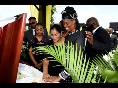 
From left: Grandson Shea Stewart, granddaughter Carmen-Elena Stewart, daughter-in-law Fiorella Stewart and daughter Dr Carolyn Stewart pay their final respects to Dr Carmen Stewart  during her thanksgiving service at the National Stadium yesterday.