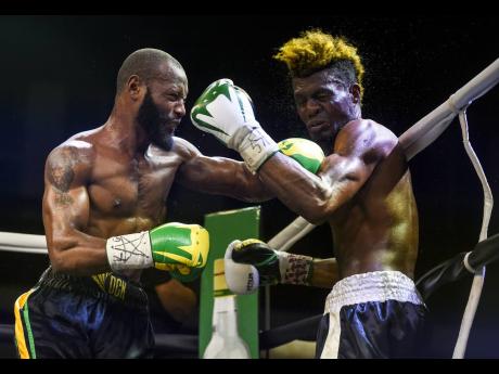 Edmund Declou Grimaces (right) reacts to a left hook from Jamaican boxer Sakima ‘Mr Smooth’ Mullings during the Kemahl ‘Hitman; Russell vs Michi Munoz title fight card at the National Arena on Friday March 16, 2018.