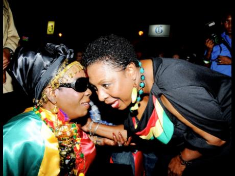 Rita Marley (left) exchanges greetings with Minister Grange.