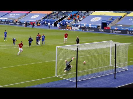 Manchester United’s Bruno Fernandes (left) scores their opening goal from the penalty spot during their English Premier League match against Leicester City at the King Power Stadium in Leicester, England, yesterday.