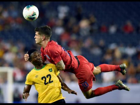 United States midfielder Christian Pulisic heads the ball above Jamaica midfielder Devon Williams during the second half of a Concacaf Gold Cup semi-final match on Wednesday, July 3, 2019.