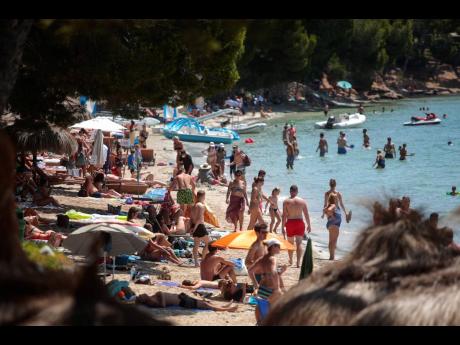 Sunbathers enjoy the beach on the Balearic Island of Mallorca, Spain, on Tuesday. 
