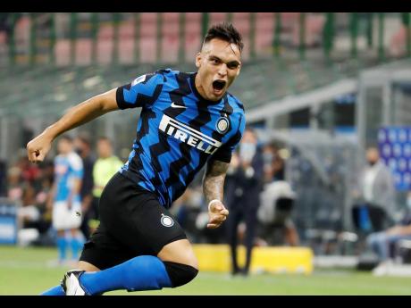 Inter Milan’s Lautaro Martinez, right, celebrates after scoring his side’s second goal during the Serie A match between Inter Milan and Napoli at the San Siro Stadium, in Milan, Italy, yesterday.