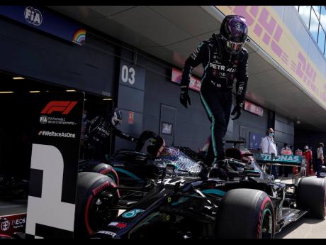 AP
Mercedes driver Lewis Hamilton celebrates after he clocked the fastest time during the qualifying session for the British Formula One Grand Prix at the Silverstone racetrack, Silverstone, England, yesterday. The British Formula One Grand Prix will be he