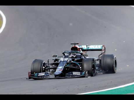 Mercedes driver Lewis Hamilton of Britain closes in on victory in spite of a puncture to his left front tyre during the British Formula One Grand Prix at the Silverstone racetrack, Silverstone, England, yesterday.