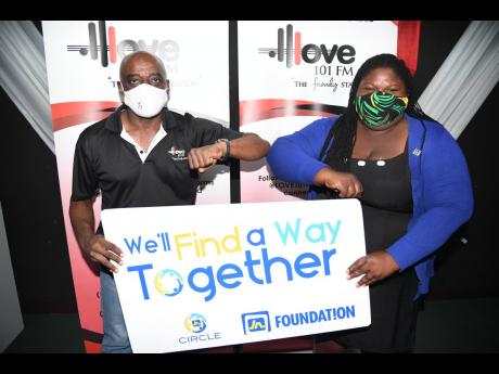 George Scott (left), sales and marketing coordinator at Love 101 FM, and Chevanese Peters, programmes coordinator at the JN Foundaion, bump elbow after the vouchers were handed over to the radio station for distribution recently.