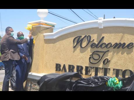 Prime Minister Andrew Holness (left) and Tourism Minister Edmund Bartlett, the member of parliament for St James East Central, unveil a new sign at the entrance of the Barrett Town in the constituency on Friday, August 7.