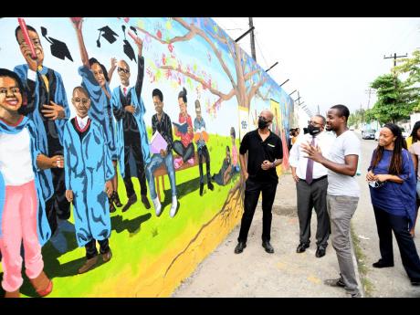 Looking at the mural from left are Clement ‘Jimmy’ Lawrence, chairman of J. Wray and Nephew; Anthony Hylton, MP; Greg Bailey, artist in charge of mural painting and design; and Miriam Hinds-Smith, dean of the School of the Visual Arts, Edna Manley Coll