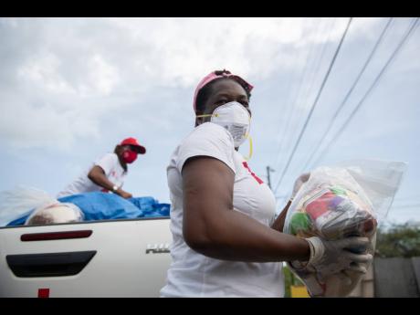 Members of the Jamaica Red Cross and Ministry of Labour and Social Security assisted with care packages and other logistics for residents throughout the community of Sandy Bay, Clarendon, on August 6, 2020, at the start of  the 14-day COVID-19 lockdown imp