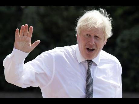 Britain’s Prime Minister Boris Johnson waves as he walks to his car following a visit to Hereford County Hospital in Hereford, England, on Tuesday, August 11. The hospital is expanding with a three storey, modular building, providing 72 new beds across t