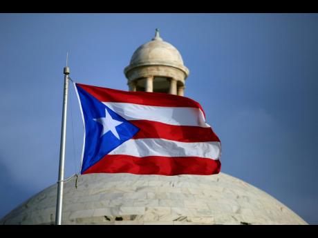 The Puerto Rican flag flies in front of Puerto Rico’s Capitol in San Juan.