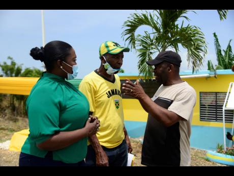 Kerensia Morrison engages two men in conversation at an Independence Day event in Springfield, St Catherine. Morrison is seeking office as the member of parliament for St Catherine North Eastern in the September 3 polls.