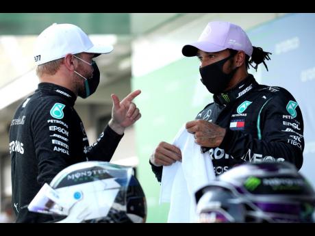 Mercedes driver Lewis Hamilton (right) talks to teammate Valtteri Bottas after the qualifying prior to the Formula One Grand Prix at the Barcelona Catalunya racetrack in Montmelo, Spain, yesterday.