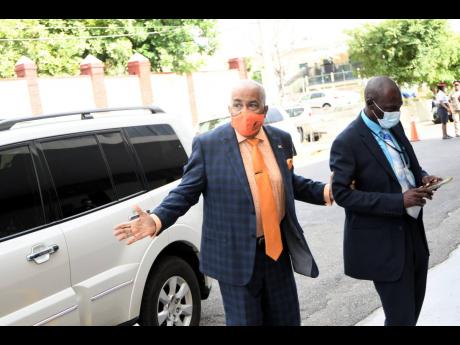 Bobby Pickersgill (left) is escorted into Gordon House, the seat of Jamaica’s Parliament, for the last time in representational politics on August 11. Pickersgill has won every election in St Catherine North Western since 1989.  