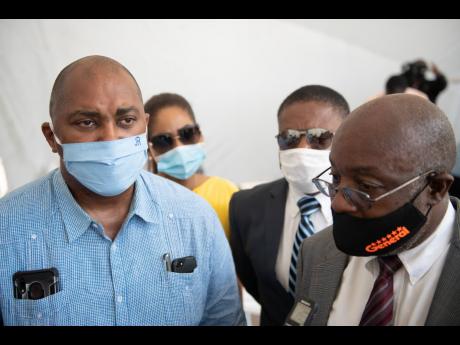 PNP General Secretary Julian Robinson is seen alongside party Chairman Fitz Jackson at a ceremony for the signing of the Political Code of Conduct in New Kingston on August 19.