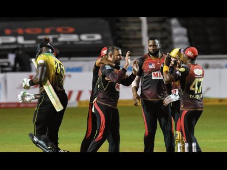 Fawad Ahmed (second left) of Trinbago Knight Riders (TKR) celebrates the dismissal of Carlos Brathwaite (left) of Jamaica Tallawahs during the Hero Caribbean Premier League between Trinbago Knight Riders and Jamaica Tallawahs at Brian Lara Cricket Academy 