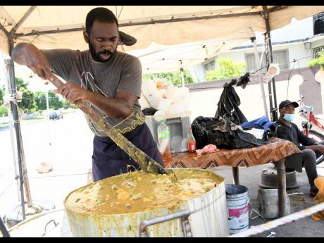 Clifton James stirs a massive pot of piping-hot soup along Bay Farm Road in Kingston on Friday. James is concerned that the tightened curfew hours that take effect today will cramp business.