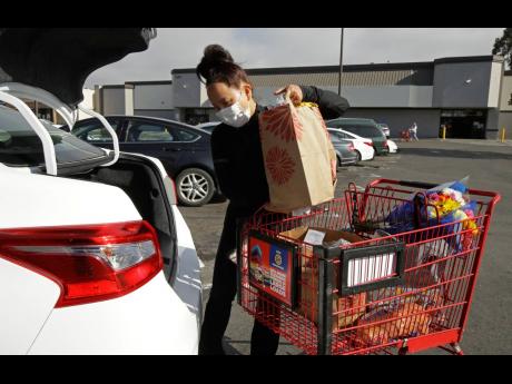 AP
In this July 1, 2020 photo, Instacart worker Saori Okawa loads groceries into her car for a home delivery in San Leandro, California.