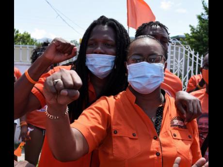 Damion Crawford, PNP vice-president, escorts Venesha Phillips, candidate for St Andrew Eastern, to the nomination centre at Mona High School on Tuesday, August 18.