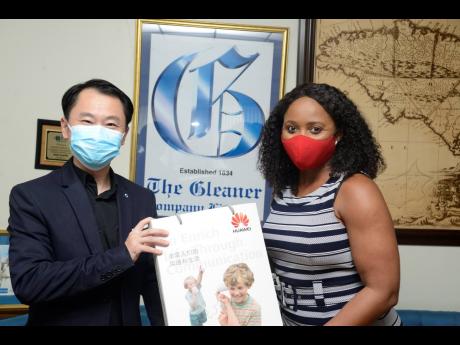 Andy Deng (left), Huawei country manager of for Jamaica, hands over masks to Kaymar Jordan, editor-in-chief,  The Gleaner Company Media Ltd, on August 27 at The Gleaner’s North Street office. 