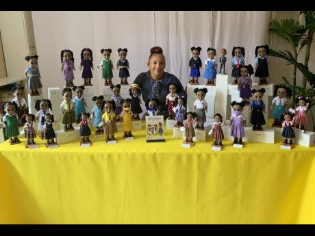 Karis Bailey poses with the dolls in school uniforms that she created.