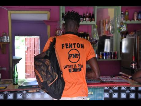 A Fenton Ferguson supporter stops at a bar in Duckenfield, St Thomas Eastern, on Saturday. Ferguson will challenge Dr Michelle Charles for the seat on September 3.