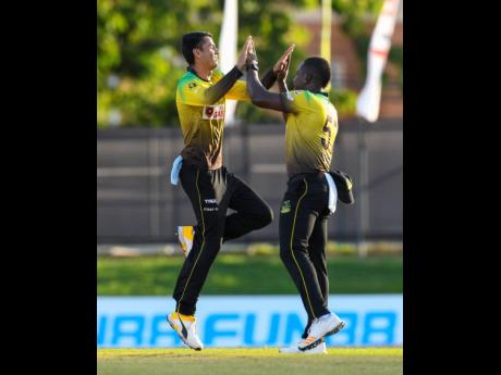 Mujeeb-ur-Rahman (left) and Rovman Powell (right) of Jamaica Tallawahs celebrate the dismissal of Shai Hope of the Barbados Tridents during the Hero Caribbean Premier League match at Queen’s Park Oval on August 26, 2020, in Port-of-Spain, Trinidad And To